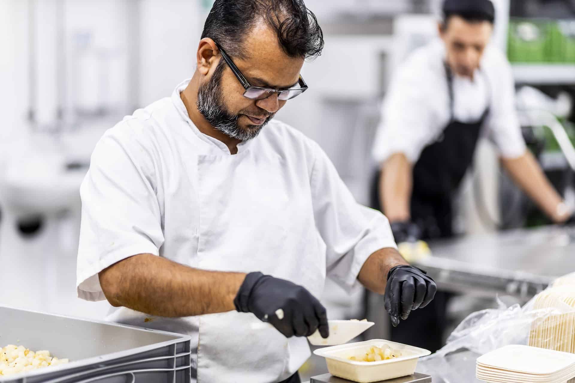 Mand vejer maden inden den pakkes